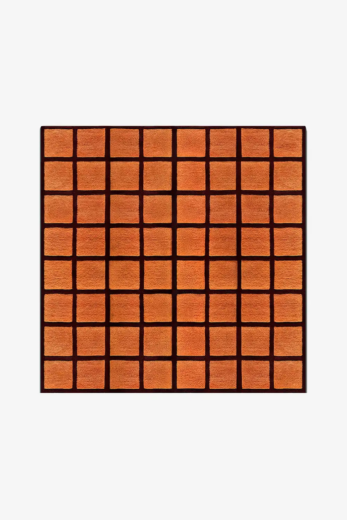 square wool rug with orange tiled pattern framed by deep burgundy wool gridlines