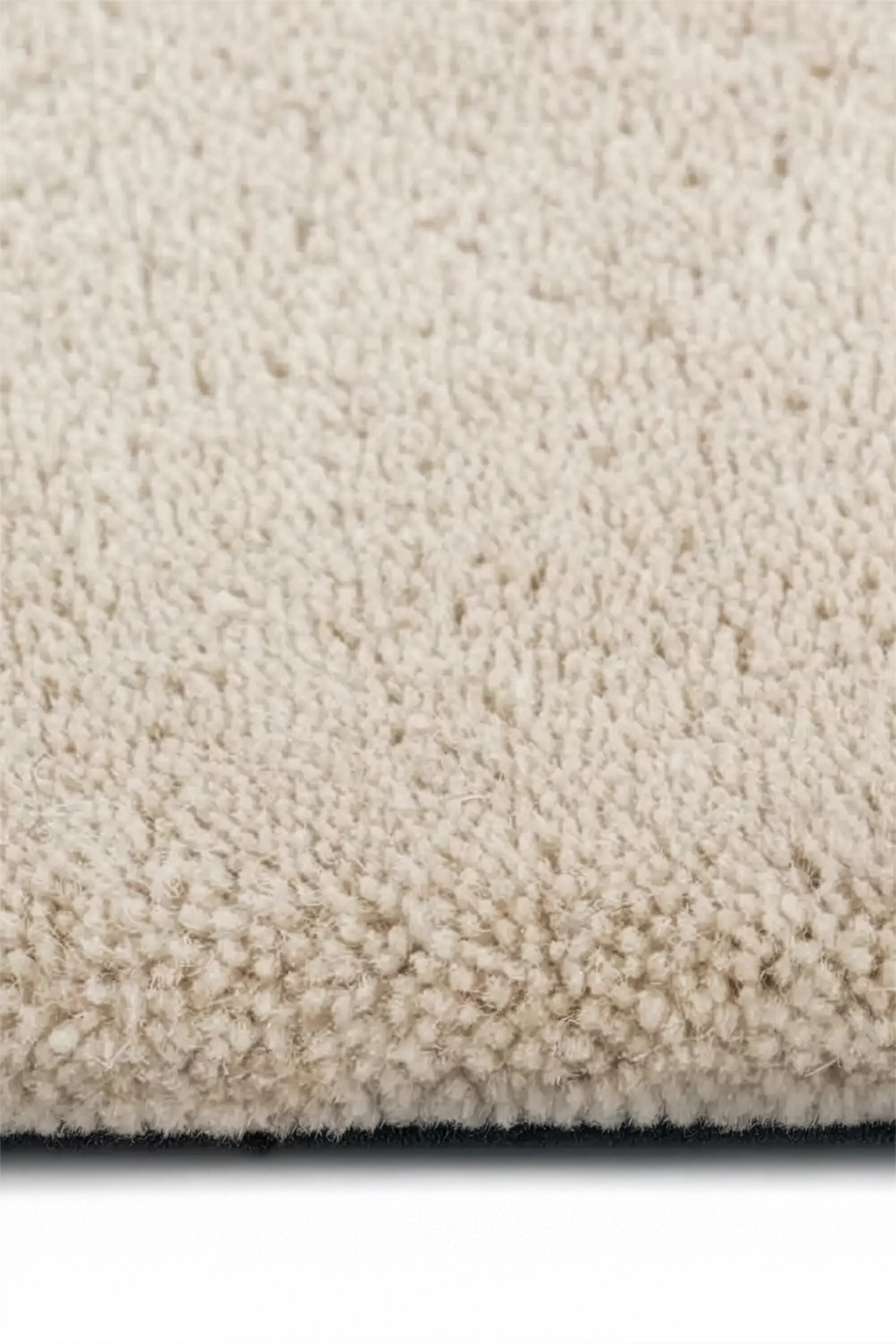 close-up of cream wool pile on hand-tufted square rug