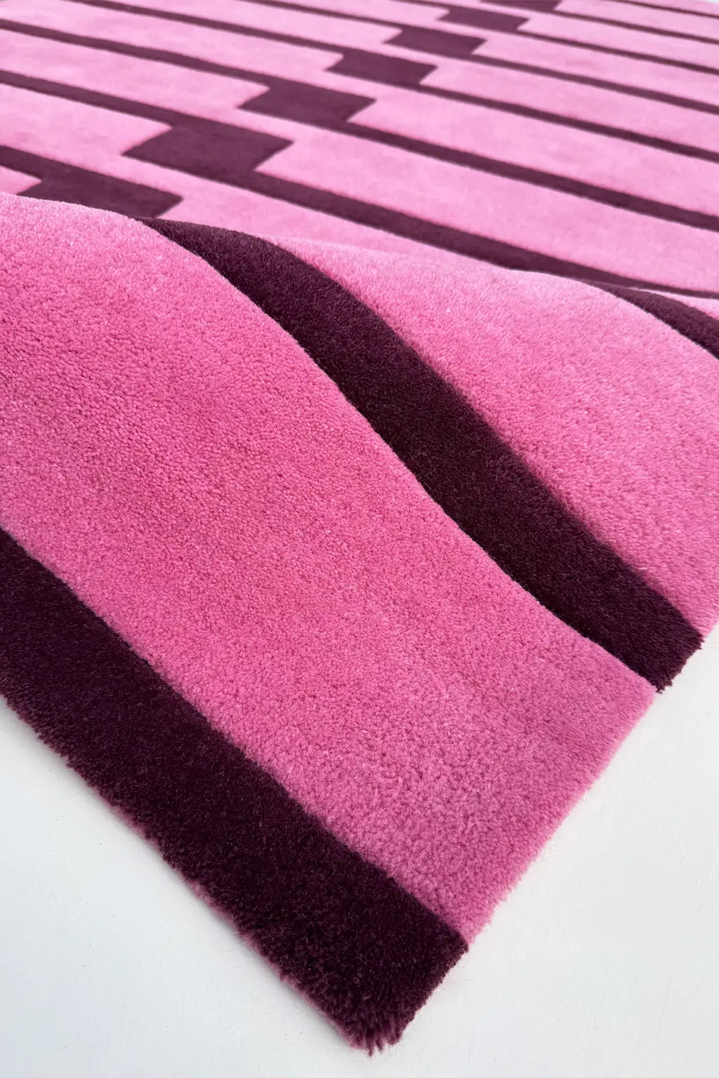 Close-up of a pink and purple striped square rug texture