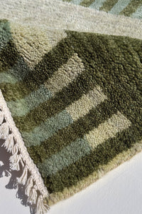 close-up view of olive and sage green striped square rug