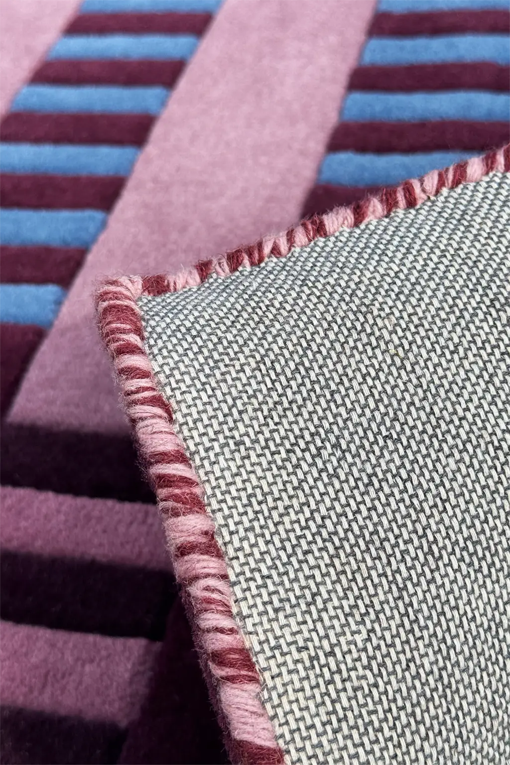 Close-up of square wool rug with striped and textured patterns