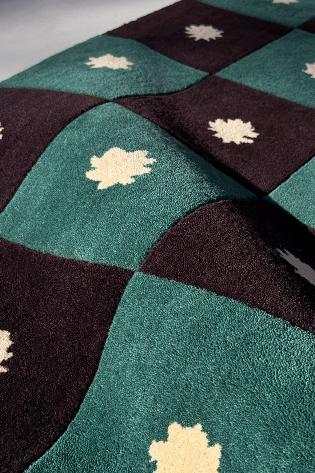 close-up texture view of green and black checkered wool rug with star patterns