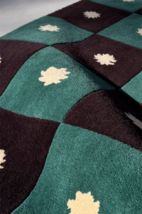 close-up texture view of green and black checkered wool rug with star patterns