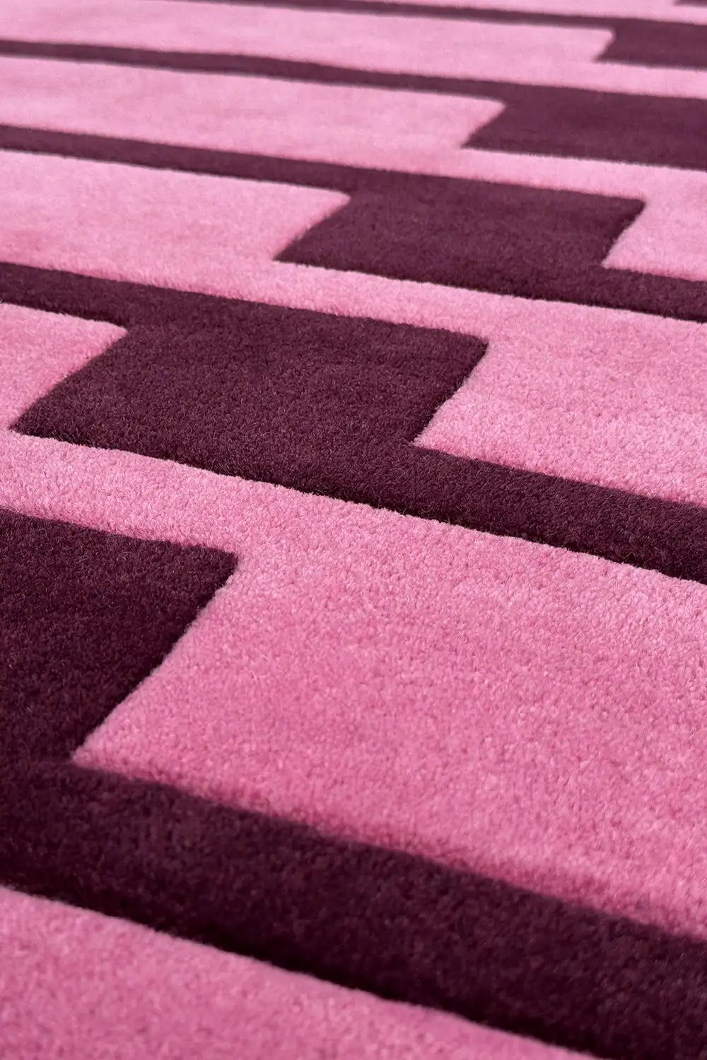 Close-up of a bright pink and purple geometric patterned rug