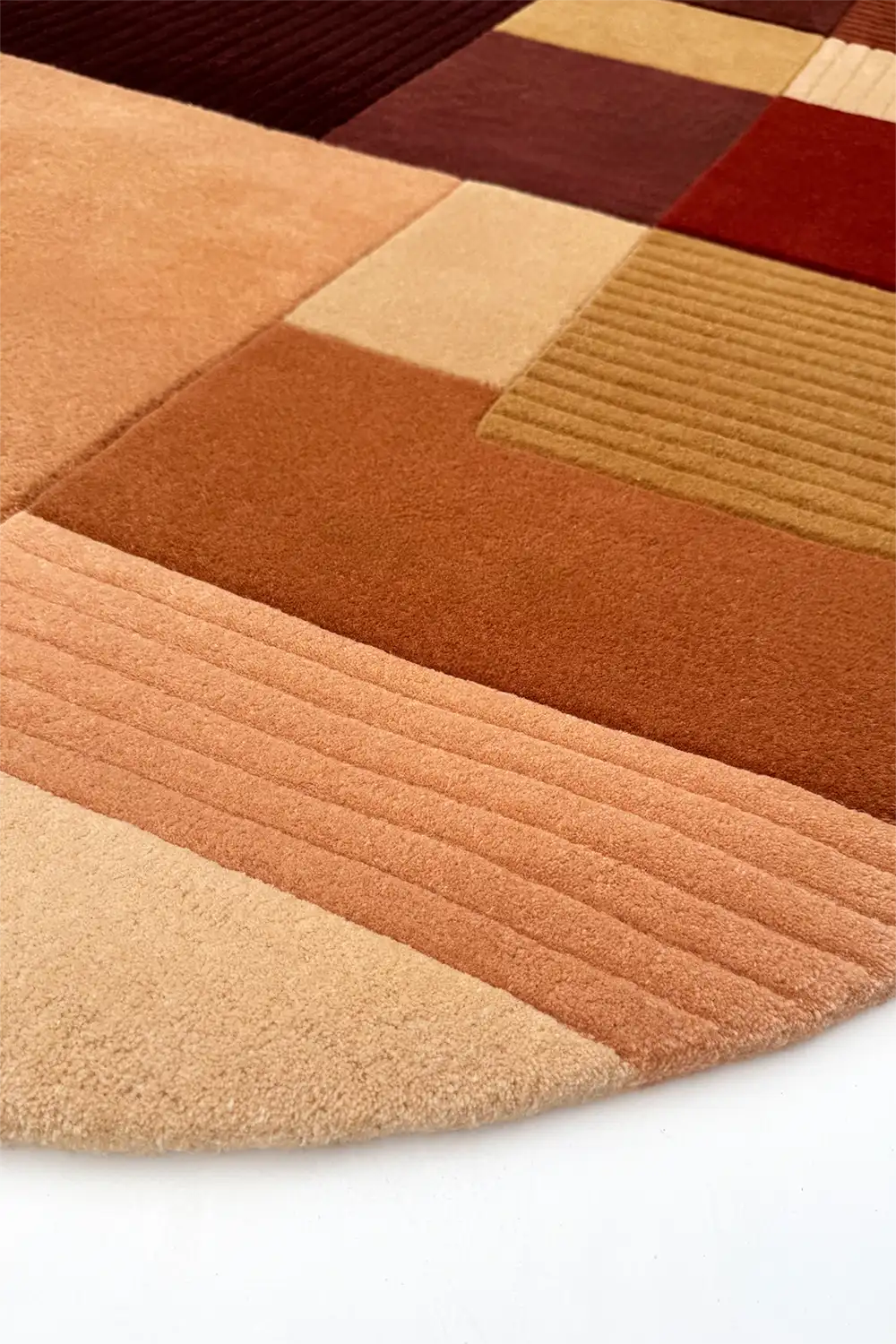 Close-up of a round multicolored geometric-patterned rug with shades of brown and beige.