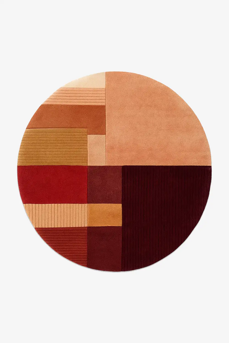 Round rug with a patchwork design in earthy tones on a white background