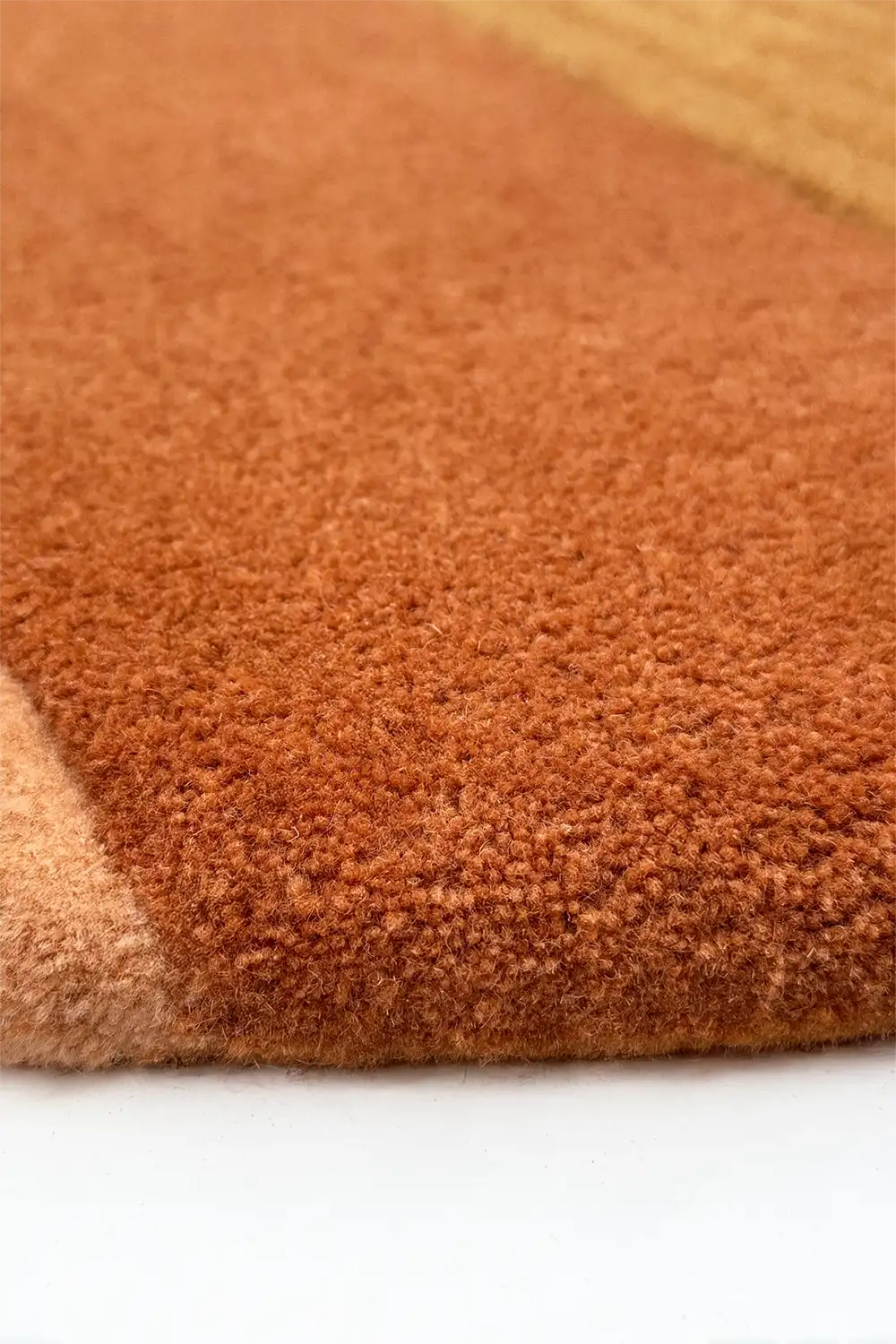 Close-up of a brown and orange textured rug on a white background