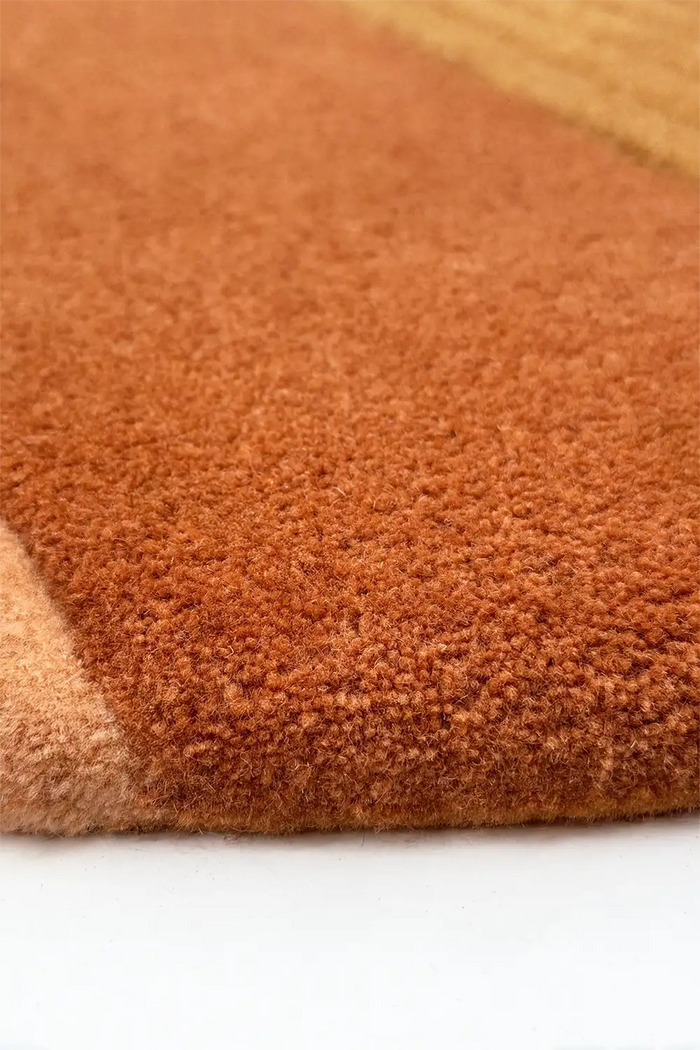 Close-up of a brown and orange textured rug on a white background