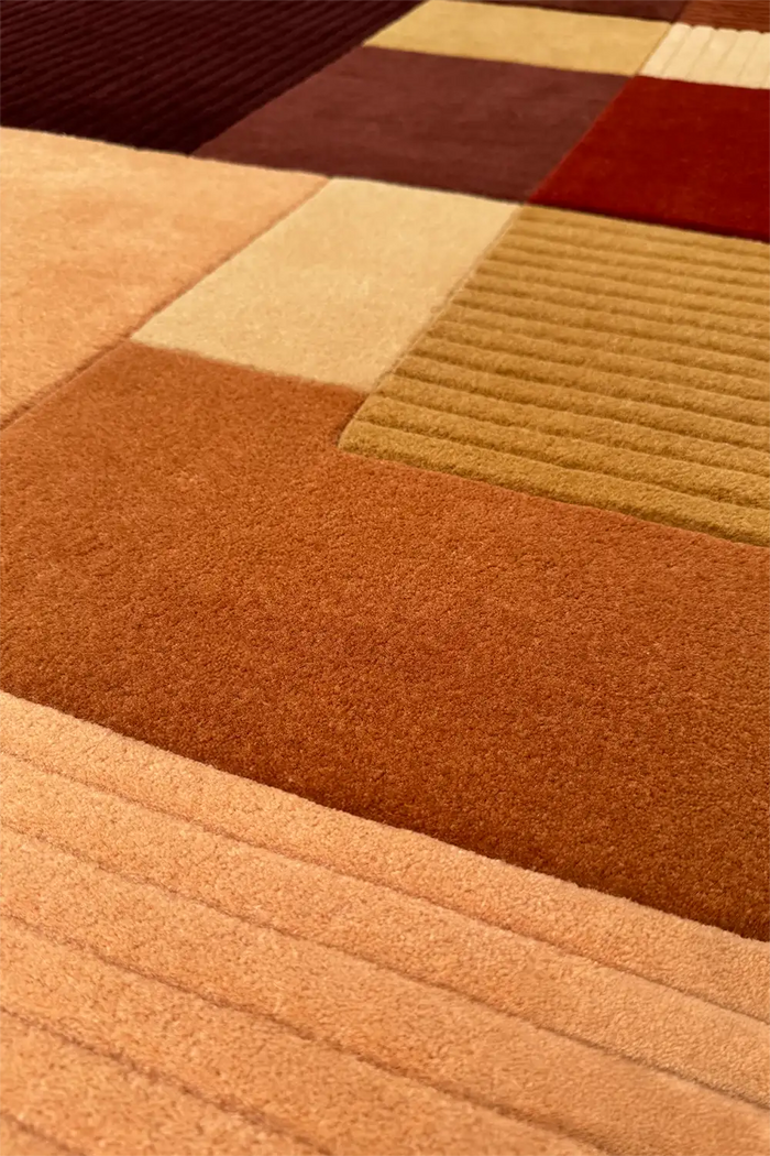 Close-up of a textured rug with geometric pattern in earthy tones.
