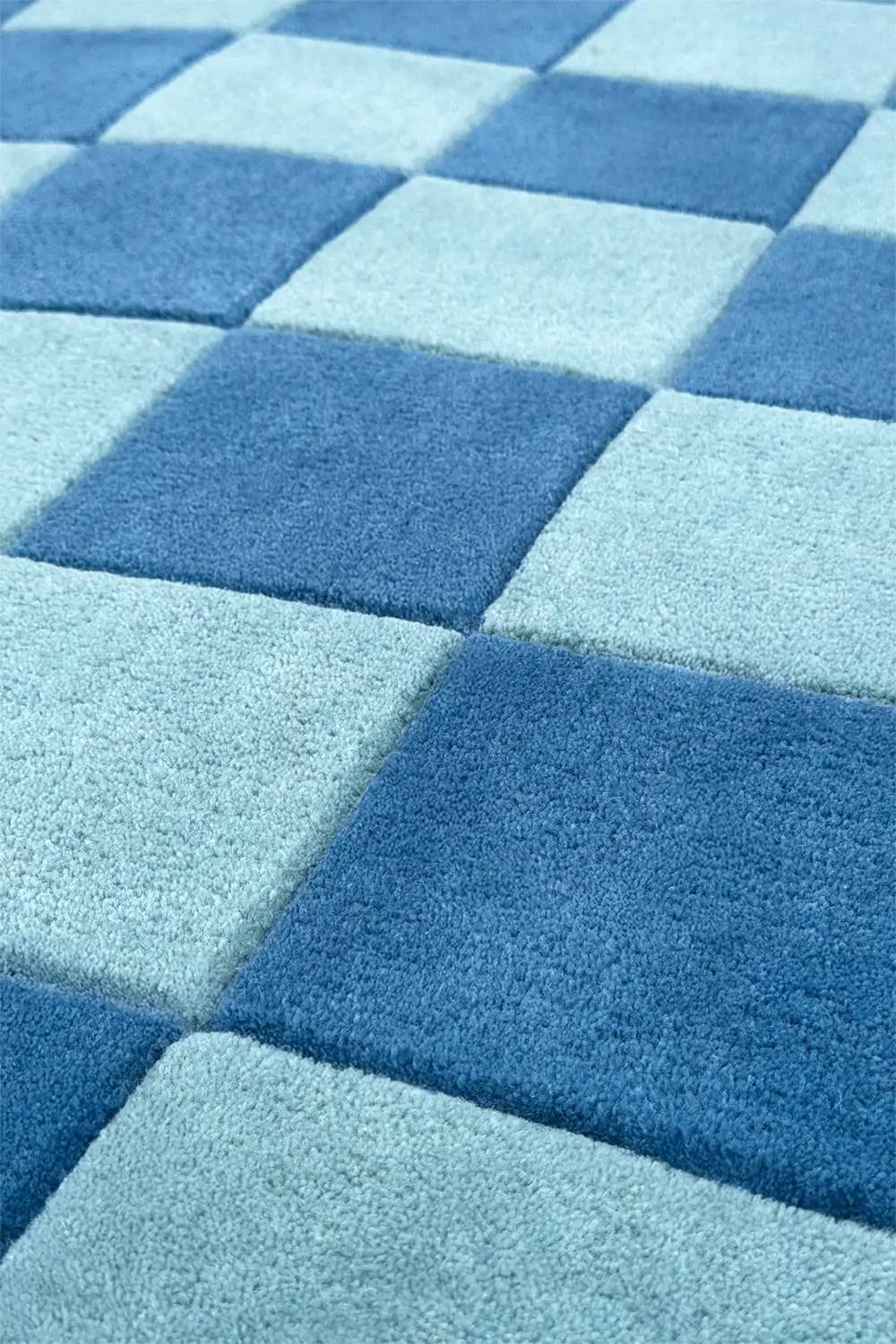 Close-up of blue square tiled geometric rug with soft hand tufted wool texture