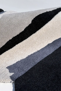 Close-up of textured runner rug with black, gray, and white stripes silver