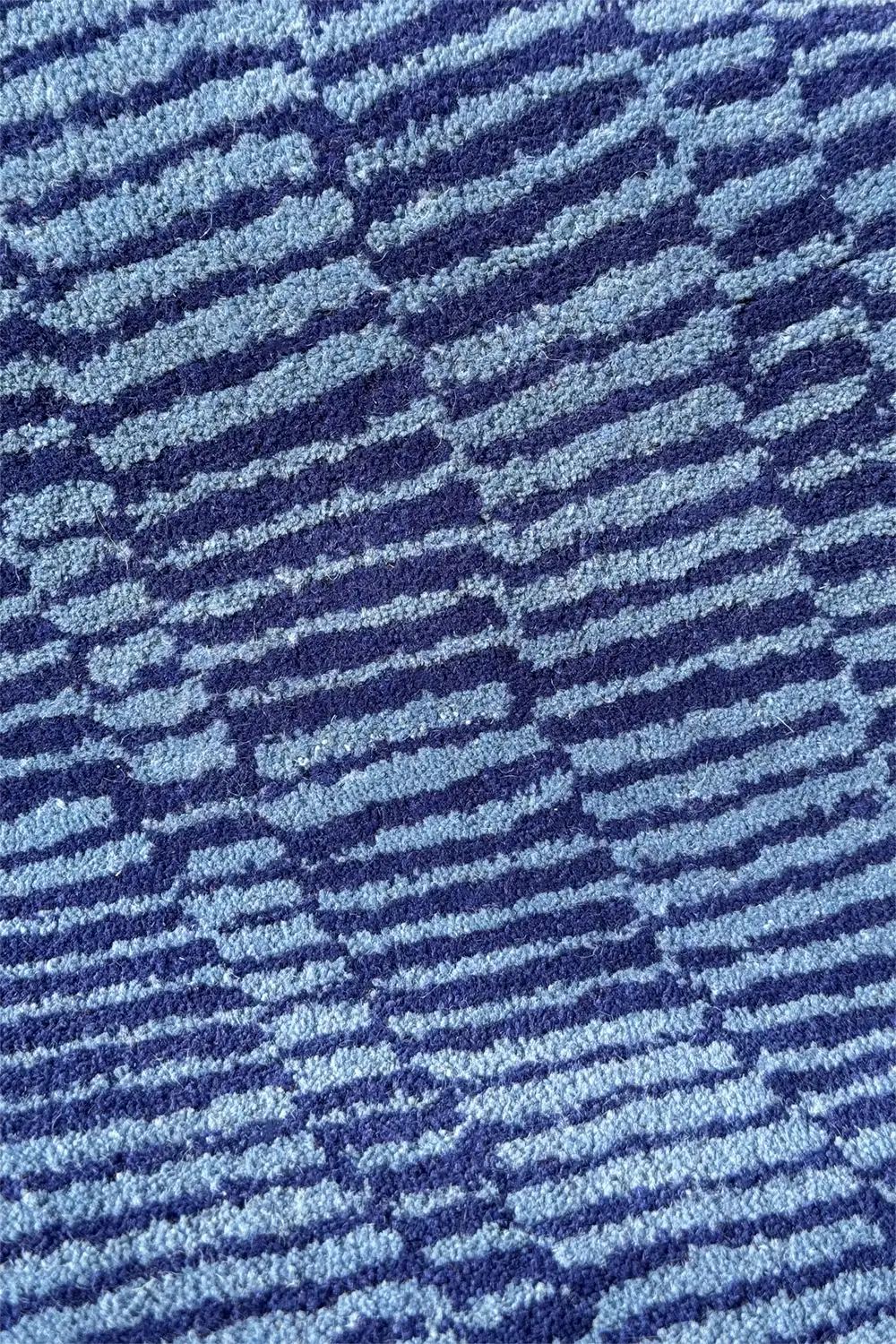 Light blue striped wool rug with a textured wavy surface
