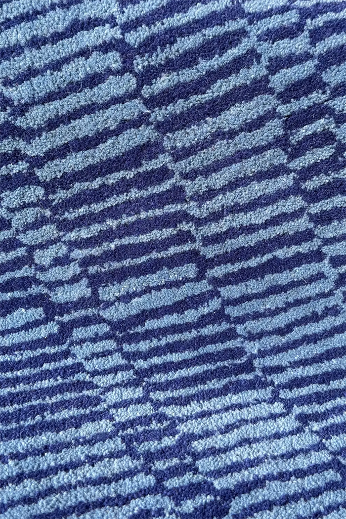 Light blue striped wool rug with a textured wavy surface

