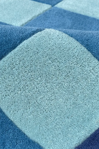 Close-up of a blue checkered patterned rug in hand-tufted wool