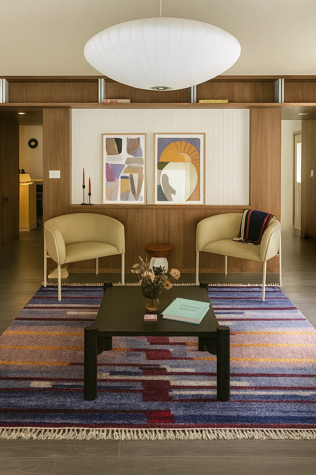 Living room with a multicolor striped modern rug two beige chairs, a coffee table, and abstract art on the wall lifestyle