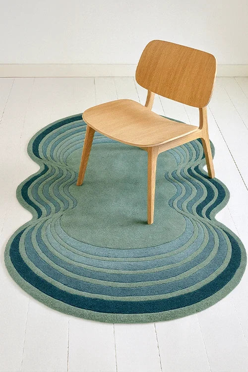Wavy blue rug on a white floor with a wooden chair