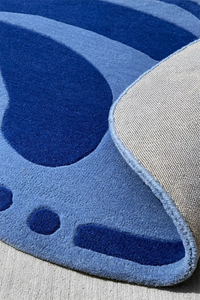 Unique blue abstract rug in an irregular oval shape, bold modern wool rug for living room or office