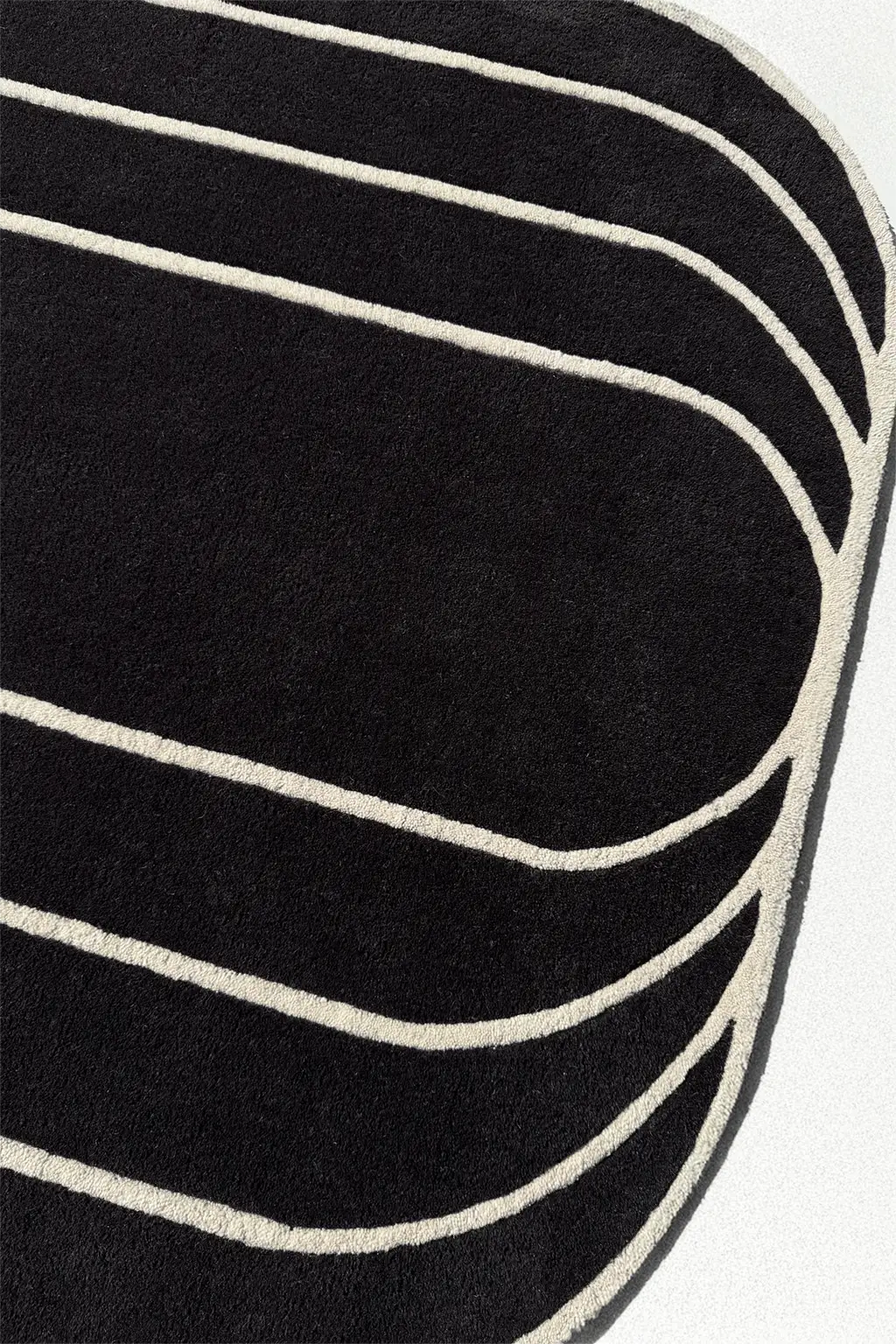 Close-up of a black rug with white stripes on a white background
