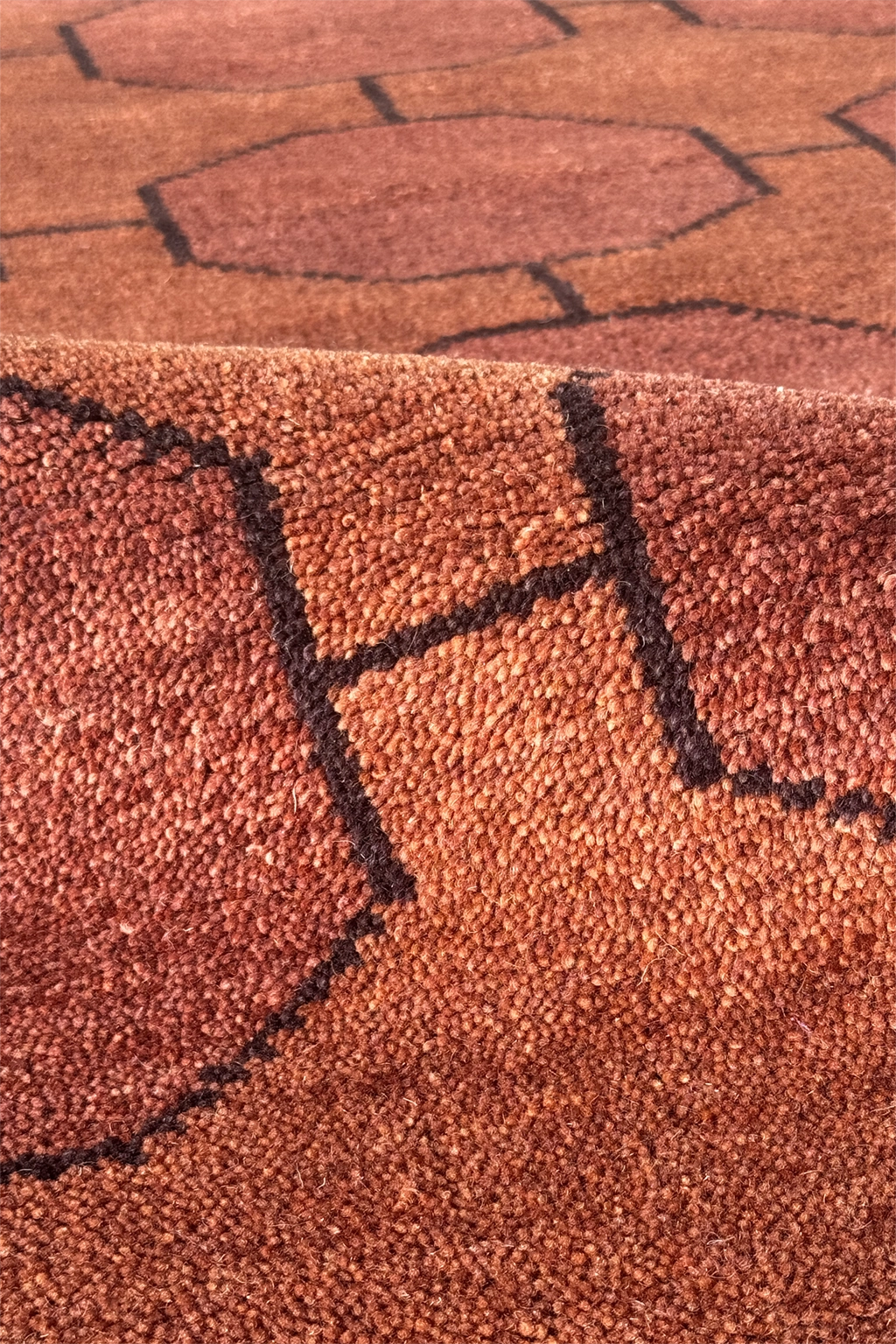 Close-up of a textured earthy brown rug with geometric pattern