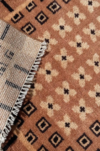 Corner detail of hand knotted wool rug with cream fringe and mid-century inspired geometric patterns