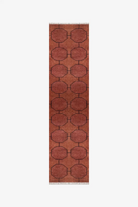 Long brown runner rug with geometric pattern on a white background