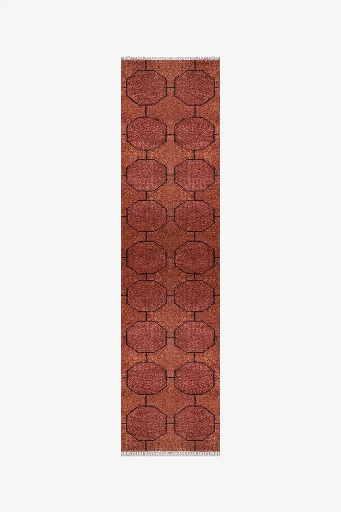 Long brown runner rug with geometric pattern on a white background