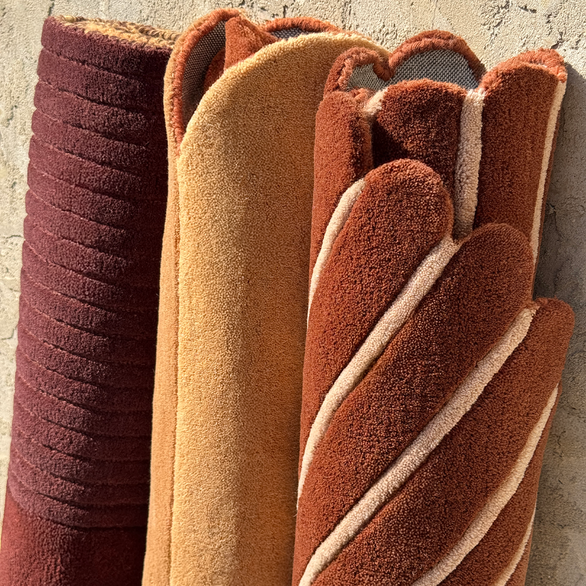 Three textured rugs in different colors on a neutral background