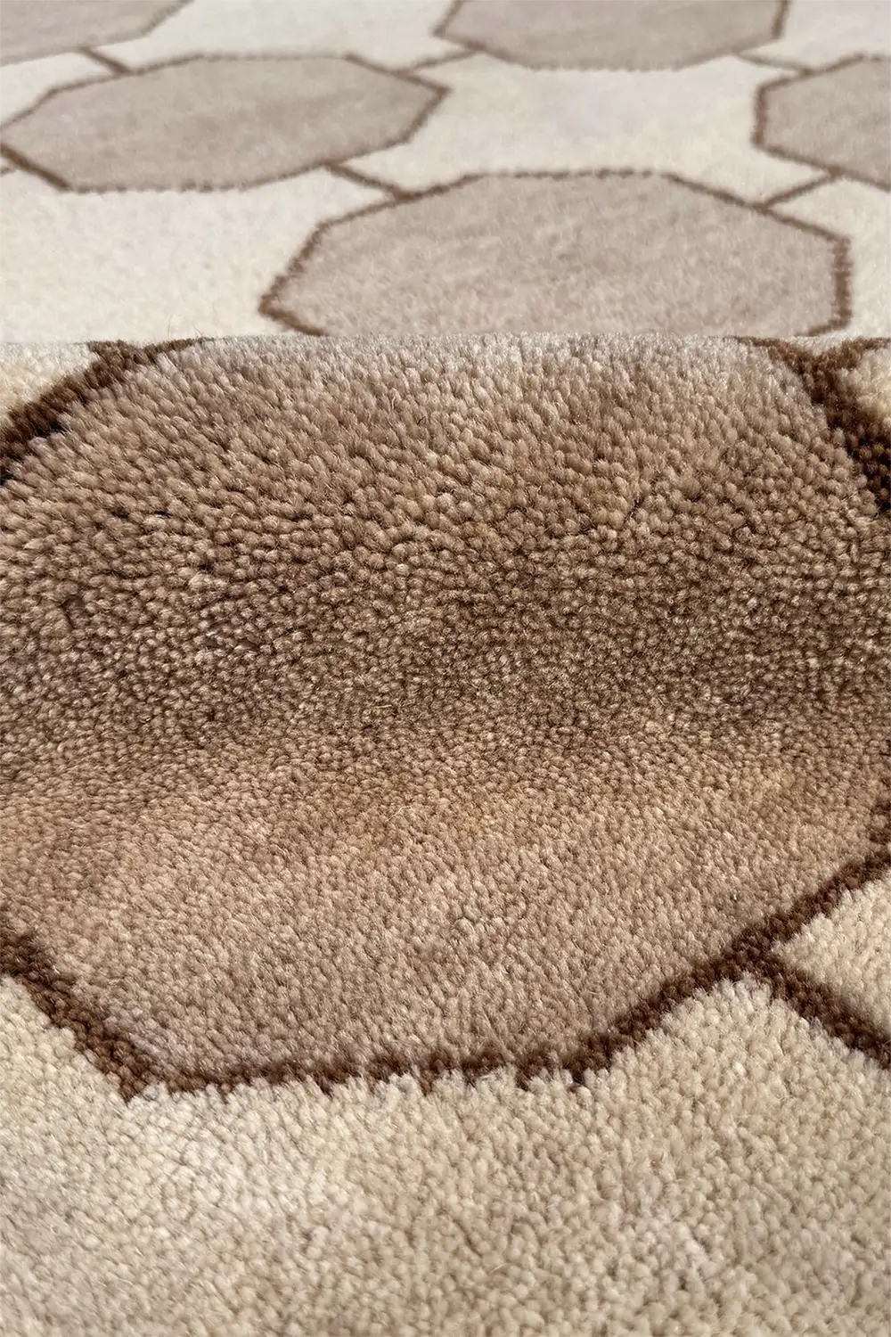Close-up of a textured brown and beige mid century modern style rug with geometric pattern ivory