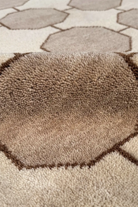 Close-up of a textured brown and beige mid century modern style rug with geometric pattern ivory