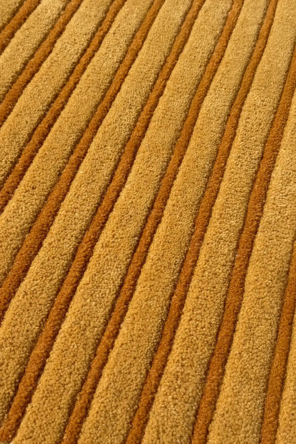 close-up of gold and orange stripes on a modern round wool rug