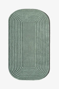 Sage green oval rug with concentric carved lines, a minimalist Japandi-inspired 4x6 or 5x7 organic wool rug for entryways or bedrooms