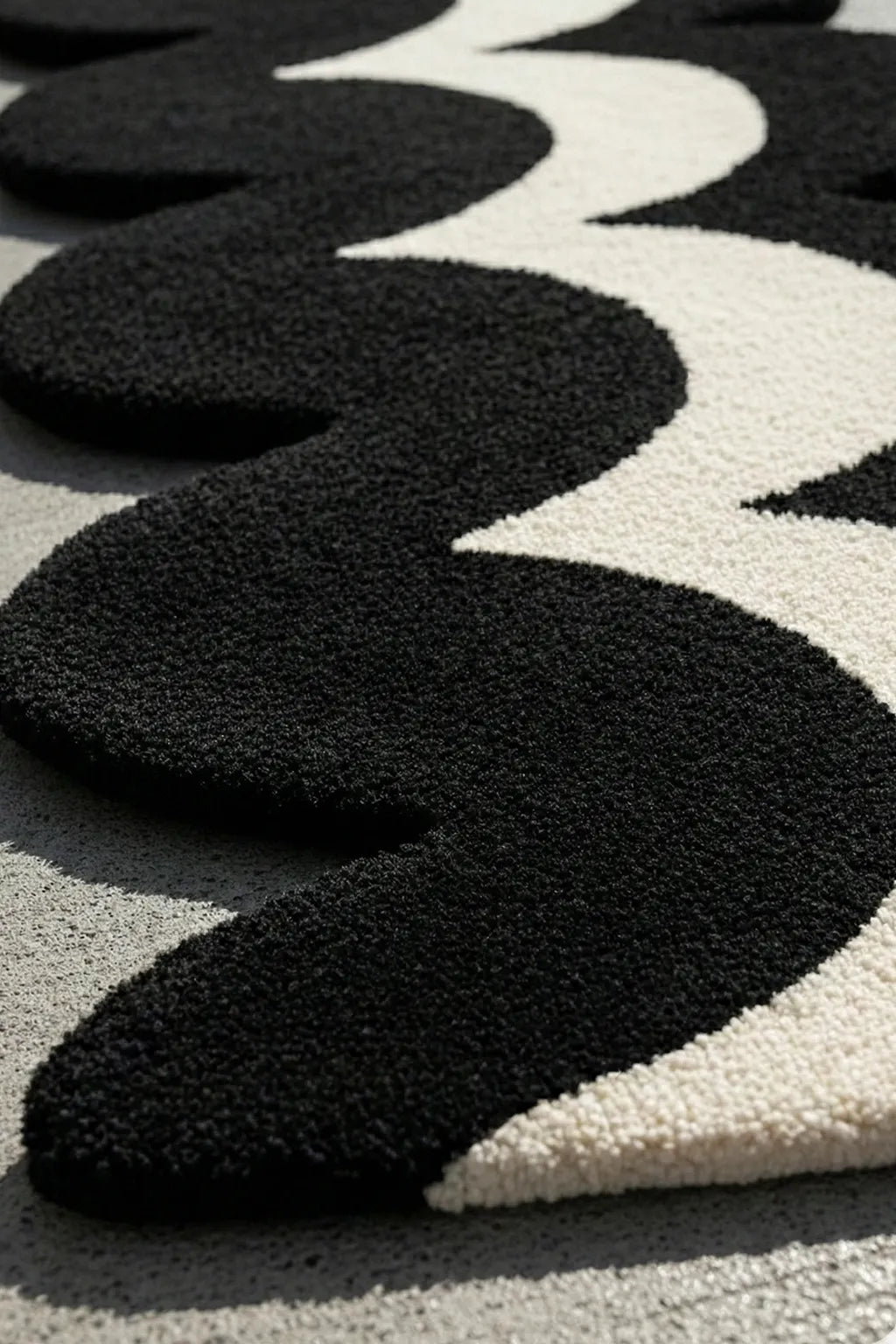 close up view of tufted black and white runner rug with irregular wavy shape