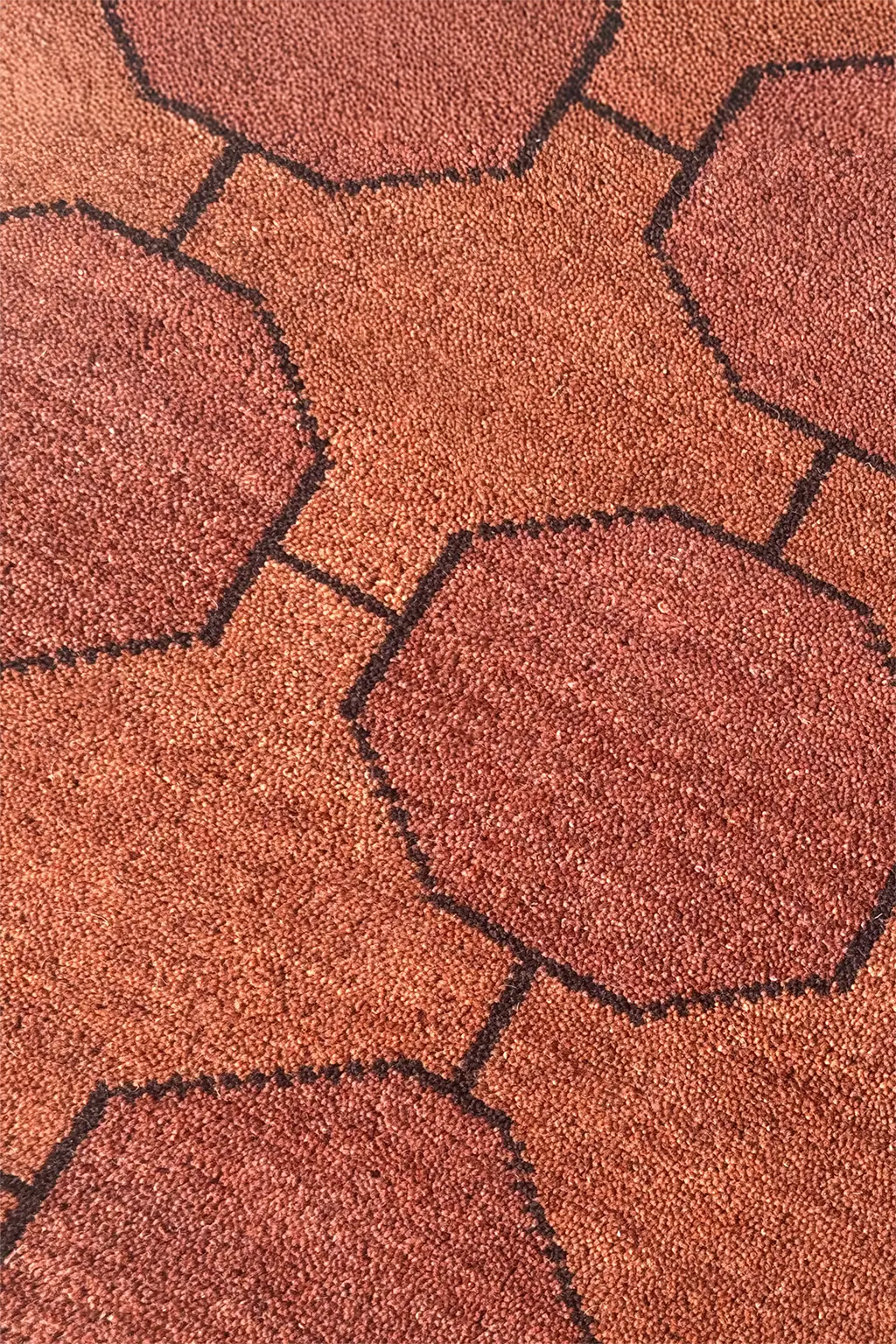 Close-up of a textured runner rug with geometric patterns in warm dark brown