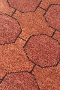 Close-up of a textured runner rug with geometric patterns in warm dark brown