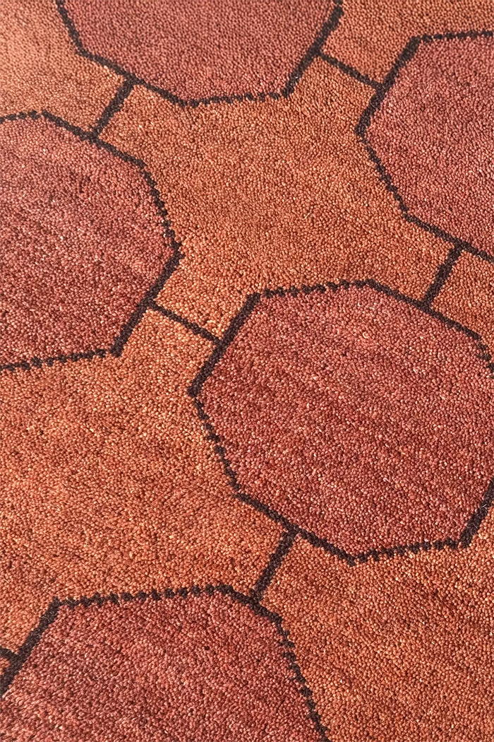 Close-up of a textured runner rug with geometric patterns in warm dark brown