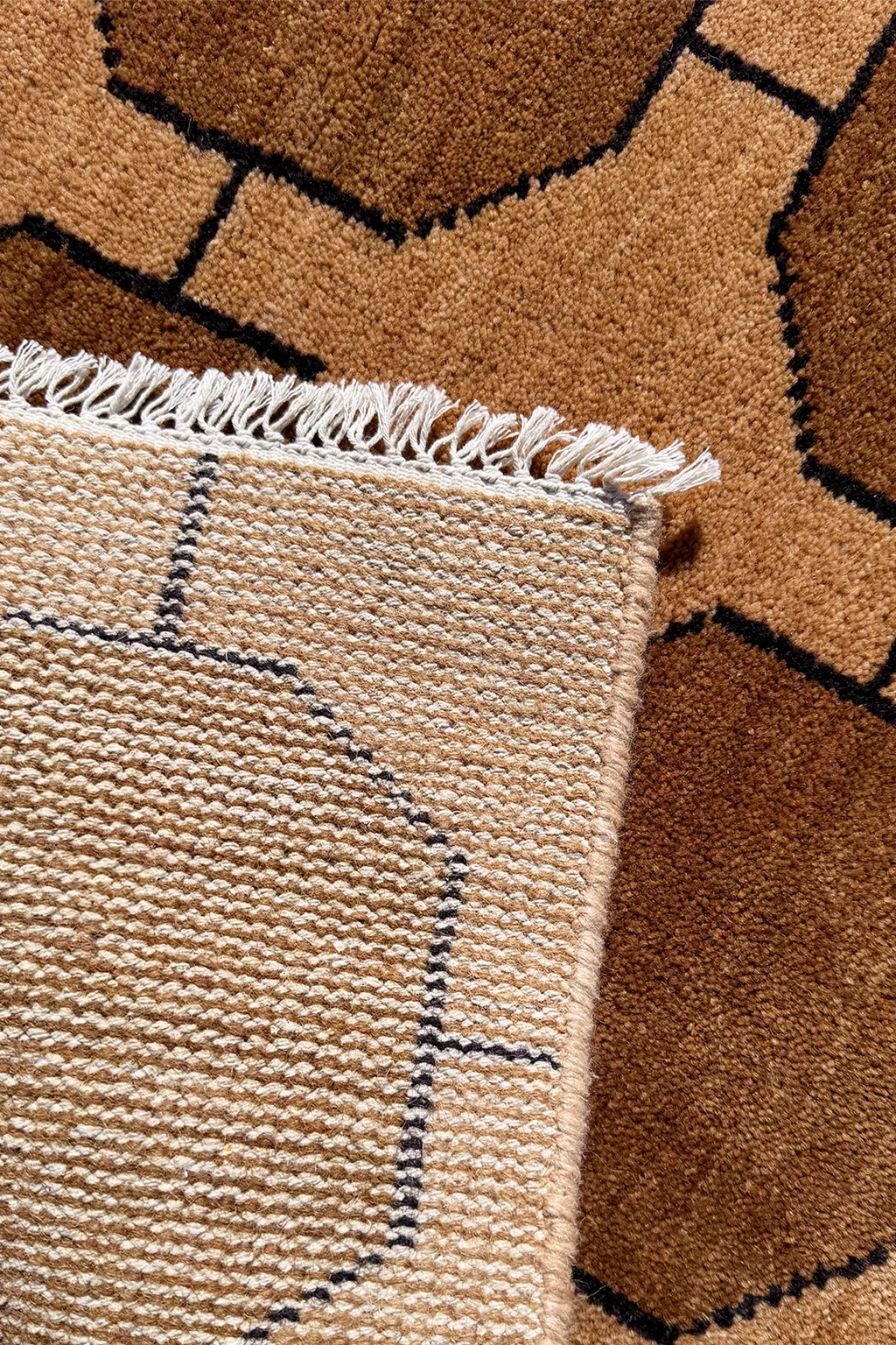 Close-up of a textured runner rug with geometric pattern and fringed edge.