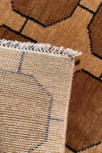 Close-up of a textured runner rug with geometric pattern and fringed edge.