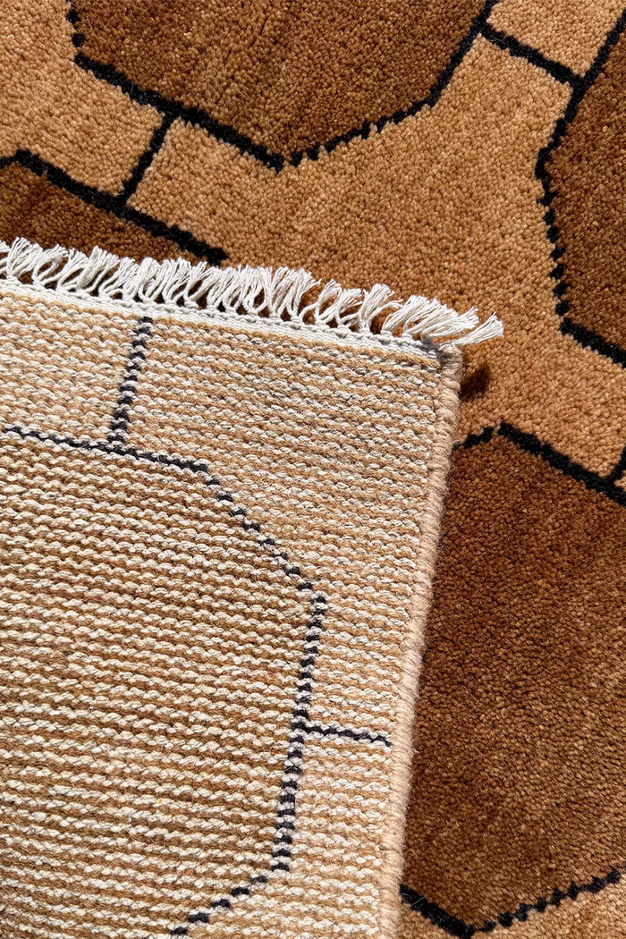 Close-up of a textured runner rug with geometric pattern and fringed edge.
