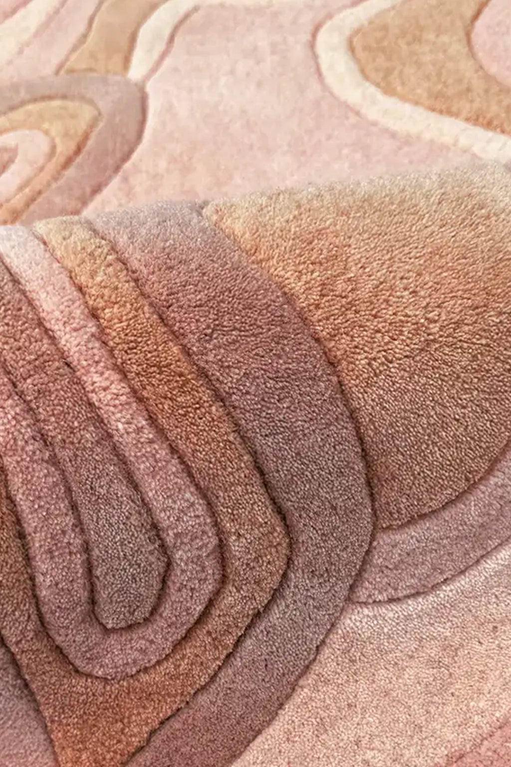 A close-up of a plush, layered area rug with organic, wavy contour lines in shades of rust orange