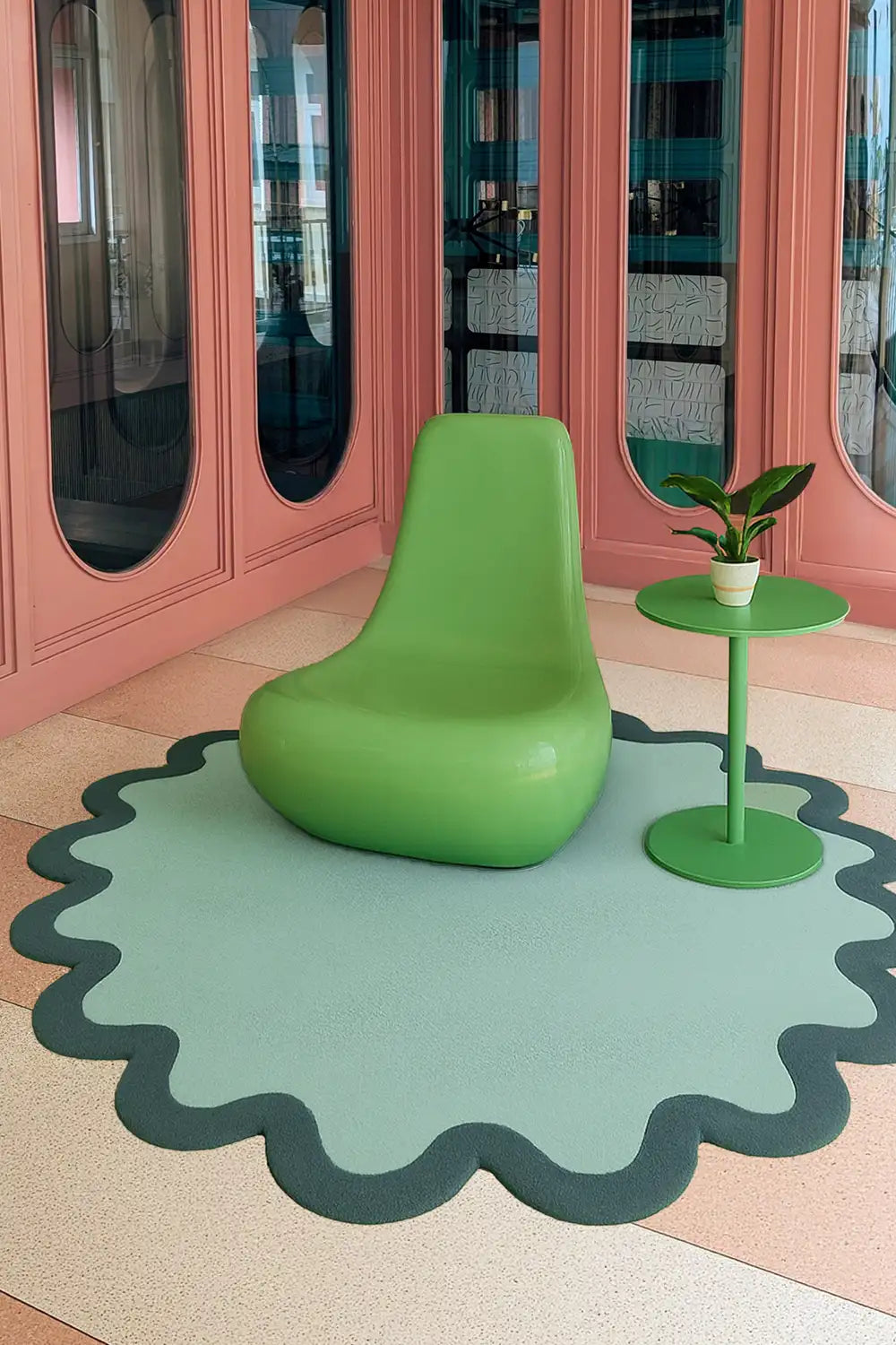 Sculptural sage green wool rug with forest green wavy edges styled in colorful mid century space