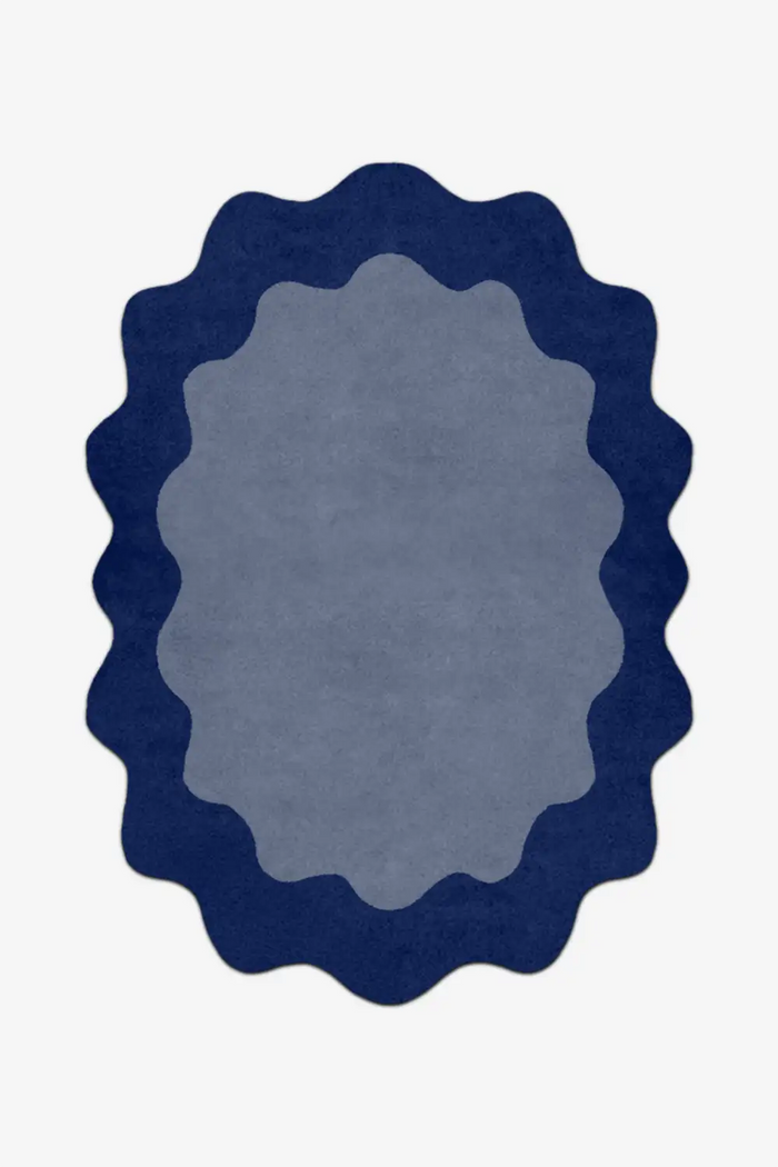 Round blue rug with scalloped edge on a white background