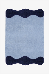 A rectangular area rug with a textured light blue center and dark navy wavy borders at the top and bottom, shown flat against a plain white background.