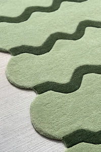 soft wool texture of a modern sage green scalloped irregular shaped wool area rug