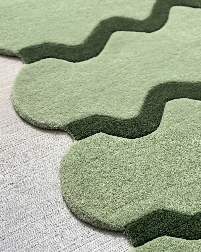 Sculpted edge green wool rug with modern scalloped design, organic wavy area rug for contemporary spaces
