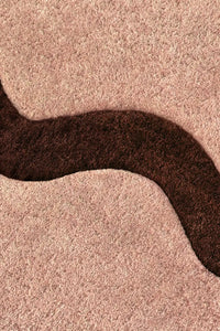 Detailed view of brown wave stripe on tan neutral rug, funky modern scalloped wool rug