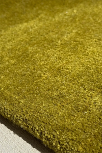 Close-up of a textured green wool round rug
