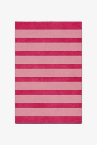 Rectangular pink and red striped rug on a white background