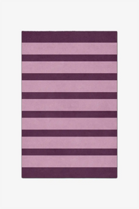 Purple and pink striped rug on a white background