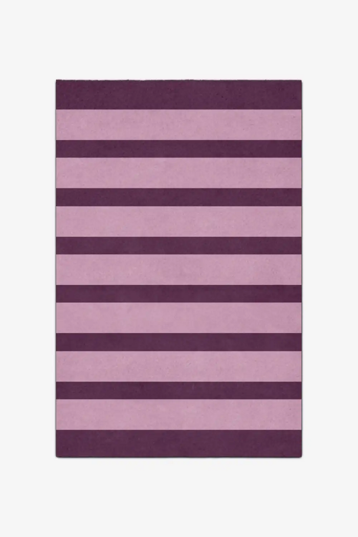 Purple and pink striped rug on a white background