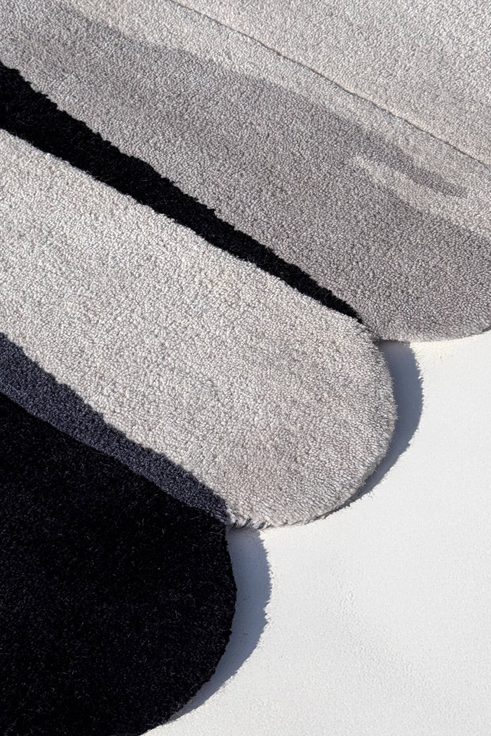 close-up texture of silver scalloped wool rug with gray and black design